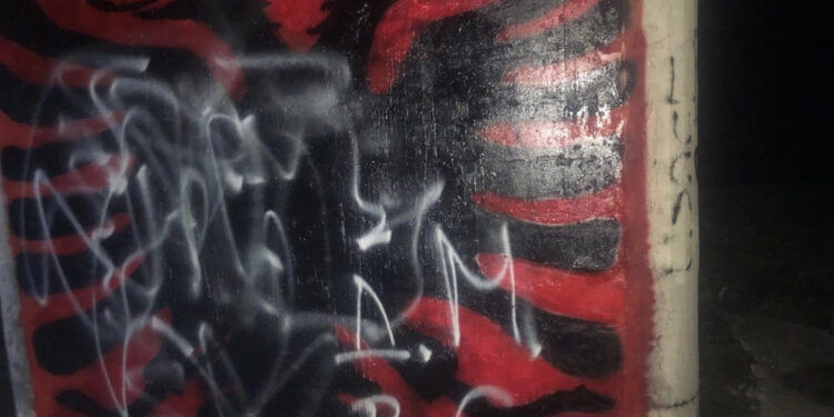 Vandalizmi vazhdon – Grup huliganësh sërish shkarravisin Shqiponjën kuq e zi